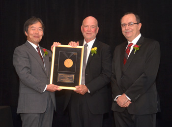 Hironori Kasahari (left) and Paolo Montuschi (right) present Sorel Reisman with the Richard E. Merwin Award for Distinguished Service.