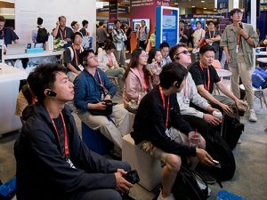 People with ear pieces in watching a screen
